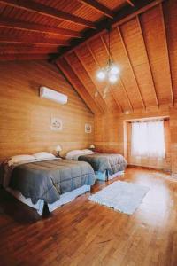 a bedroom with two beds in a room with wooden walls at Baja Vineyard Lodge - Luxury in Valle de Guadalupe with pool in Ensenada +50 photos