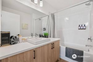 a white bathroom with a sink and a tub at Modern Luxury Townhome near Aspen Landing and Winsport in Calgary +38 photos