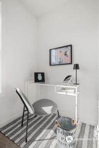 a white room with a desk and a chair at Modern Luxury Townhome near Aspen Landing and Winsport in Calgary