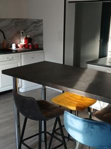 a kitchen with a black table and two chairs at Le petit meslier in Jaucourt