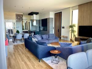 a living room with blue couches and a kitchen at Fins Dream Villas in Fins