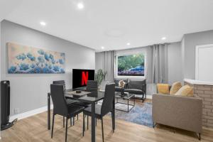 Un comedor y una sala de estar con mesa y sillas. en Stylish 3 BR Apt with Free Parking, Wifi and Patio, en Whitby
