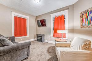 un soggiorno con divano e TV e 2 finestre di Urban Comfort Nook - Walk to Overton Park a Memphis
