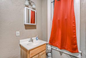 un bagno con un lavandino e una tenda da doccia rossa di Urban Comfort Nook - Walk to Overton Park a Memphis