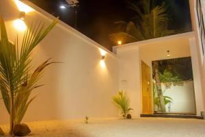 a building with a palm tree in front of a door at Equator Sandy Beach in Kondey