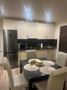 a kitchen with a table and chairs and a refrigerator at Trumpalaike buto nuoma in Panevėžys