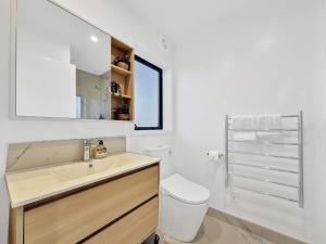 a white bathroom with a sink and a toilet at Cozy Studio with Private Yard in Christchurch CBD in Linwood +7 photos