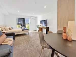 a living room with a couch and a table at Cozy Studio with Private Yard in Christchurch CBD in Linwood