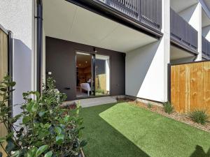 an internal courtyard of a house with green grass at Cozy Studio with Private Yard in Christchurch CBD in Linwood