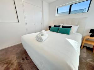 a bedroom with a large white bed with towels on it at One Bedroom Stunner in Allen Street in Linwood