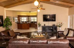 a living room with a leather couch and a tv at Spacious Luxury Estate Pool Jacuzzi Horses in Orlando