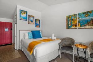 Schlafzimmer mit einem Bett mit blauer und orangefarbener Bettwäsche in der Unterkunft Lakeview Lookout - Studio Unit in Queenstown Airport