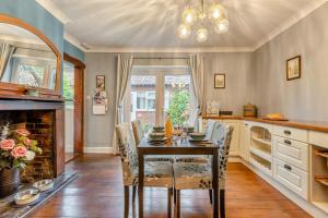 a kitchen with a table and chairs and a fireplace at Swallows Way in Briston