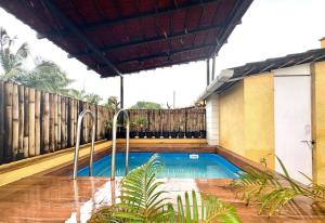 una piscina in un cortile con recinzione in legno di The Greendoor Villa - Veera Casa, pool, near beach ad Assagao