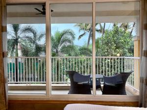 una camera da letto con finestra con vista su un balcone di The Greendoor Villa - Veera Casa, pool, near beach ad Assagao