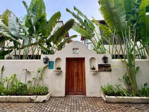 una casa con una porta in legno e alcune piante di The Greendoor Villa - Bogen, Lux, Pvt Pool, beach ad Assagao