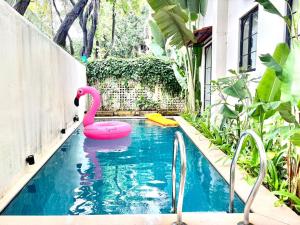 una piscina con cigno rosa in acqua di The Greendoor Villa - Bogen, Lux, Pvt Pool, beach ad Assagao