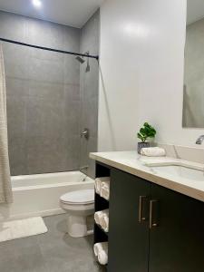 a bathroom with a toilet and a sink and a shower at Villa Cass in West End