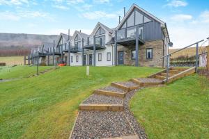 a row of houses on a grassy field at Schiehallion by Loch Tay in Chesthill
