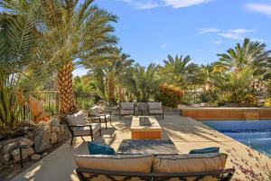 un patio con sillas y mesas junto a una piscina en Villa Barhi - A Mediterranean Palazzo, en Thousand Palms