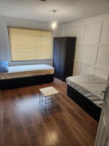 a room with two beds and a table in it at Okwute,s House in Skelmersdale