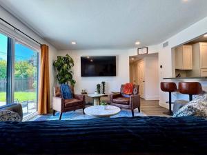 a living room with a couch and chairs and a tv at Pool Remodeled 4 Bedroom Carmichael Home in Carmichael