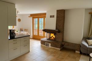 a kitchen with a fireplace in the middle of a room at Apartment with Balcony & Mountain View in Küblis