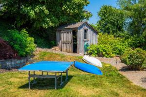 a ping pong table and a boat next to a shed at Drift Away Hot Tub Kayaks Lakefront & Games in Teall Beach