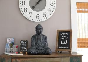 a clock on a wall with a statue on a table at Drift Away Hot Tub Kayaks Lakefront & Games in Teall Beach +30 photos