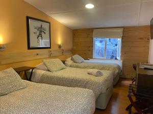 a room with three beds and a television in it at Hain Casa Hotel in Punta Arenas +127 photos
