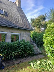 a stone house with a staircase next to a yard at Proche parc 3 curés in Coatéval