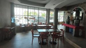 ein Esszimmer mit Tischen, Stühlen und Fenstern in der Unterkunft Hotel los coloniales in Reynosa