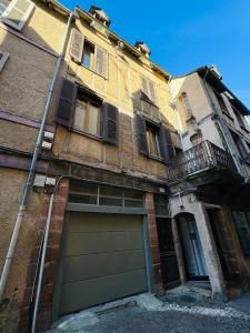 ein Gebäude mit einer Garagentür und einem Balkon in der Unterkunft Le POP au 17, appartement cosy dans le centre historique de Rodez in Rodez