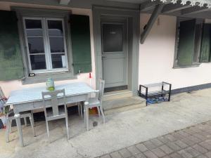 a table and chairs in front of a building at Ferienwohnung Winterzeit UG - Interlaken Thun Spiez Kandersteg in Wimmis +1 photo