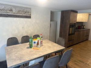 a table in a room with chairs and a kitchen at Ferienwohnung Winterzeit UG - Interlaken Thun Spiez Kandersteg in Wimmis
