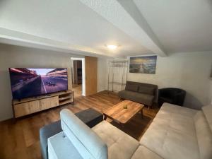 a living room with a couch and a flat screen tv at Ferienwohnung Winterzeit UG - Interlaken Thun Spiez Kandersteg in Wimmis