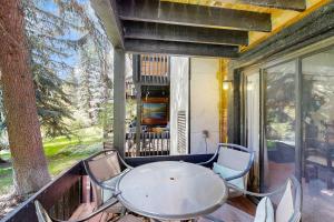 a porch with a table and chairs on a balcony at Interlochen #B9 in Vail