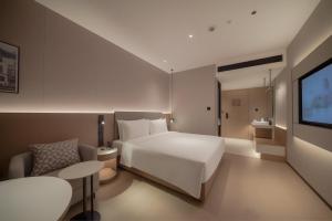a hotel room with a bed and a television at Holiday Inn Express Shanghai on The Bund by IHG in Shanghai