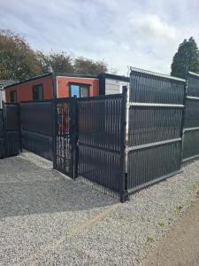 a black fence with a gate in front of a house at Cocoon in Froid-Chapelle