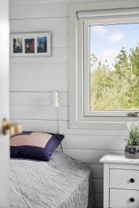 Dormitorio con ventana, cama y mesa en 2004-Romo-Ringvejen-142, en Bolilmark