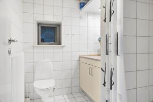 a white bathroom with a toilet and a window at 2702-Romo-Drosselvej-13 in Sønderby +30 photos