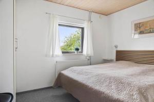 a bedroom with a bed and a window at 2702-Romo-Drosselvej-13 in Sønderby