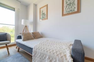 a bedroom with a bed and a chair and a window at Baiona by Ladeira in Baiona