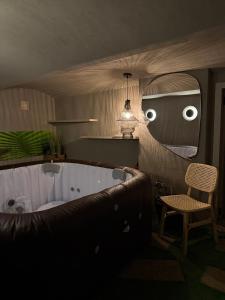 a bathroom with a tub and a chair and a mirror at Chill room PLUS in Golčŭv Jeníkov