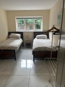 a bedroom with two beds and a window at Castell Cottages Central with Parking in Caerphilly