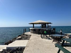 a pier with tables and chairs on the water at Thalassa Beach Resort Apartment in Vavla