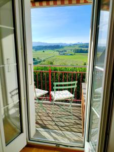 a balcony with a chair and a view of the countryside at Ornithorynque in Noréaz