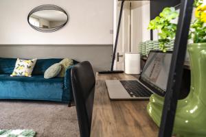 a living room with a laptop on a wooden table at Sage House (Town-Centre Flat) in Allington