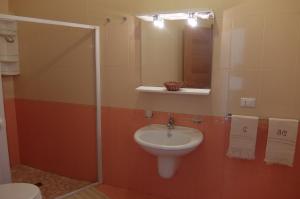 een badkamer met een wastafel, een spiegel en een toilet bij Basculla Apartments in Gagliano del Capo