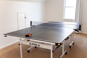 a ping pong table in a living room with at Heron Hideaway Game Room within walking distance to HWS & Seneca Lake in Geneva